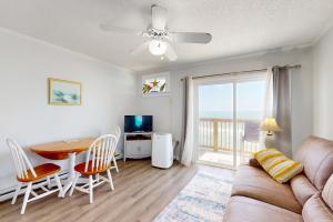 uma sala de estar com um sofá e uma mesa e uma sala de jantar em Totally Topsail! em North Topsail Beach