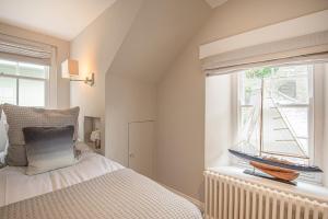 ein Schlafzimmer mit einem Bett und einem Fenster mit einem Boot darauf in der Unterkunft Pitchford House (7 Bedrooms), Salcombe. in Salcombe