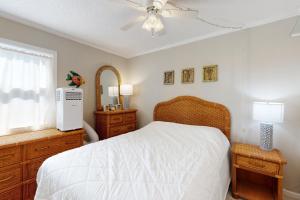 Schlafzimmer mit einem weißen Bett und einem Deckenventilator in der Unterkunft Totally Topsail! in North Topsail Beach
