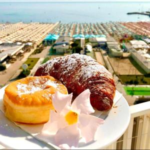 a plate with two donuts on top of a balcony at B&B Via Mare in Milano Marittima