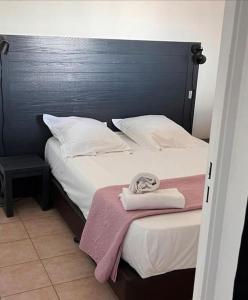 een slaapkamer met 2 bedden met witte lakens en een blauw hoofdeinde bij Appartement centre-ville d'Uzès in Uzès