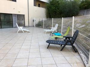 drie stoelen en een bank op een patio bij Appartement centre-ville d'Uzès in Uzès