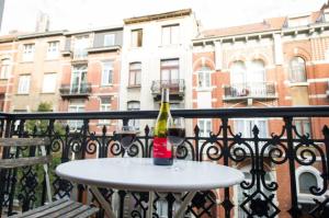 - une bouteille de vin assise sur une table sur un balcon dans l'établissement Grand appartement d'artiste cosy et proche de tout, à Bruxelles