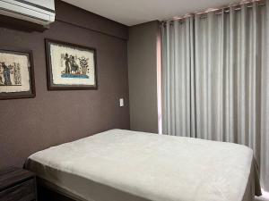 - une chambre avec un lit blanc et une fenêtre dans l'établissement Econo Brookfield Towers - Jardim Goias, à Goiânia