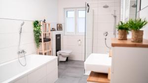 a white bathroom with a toilet and a sink at Stylischer Harztraum in Quedlinburg