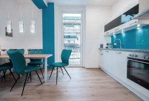 a kitchen with a table and green chairs at INNSBRUCK CENTER APARTMENTS tirol in Innsbruck