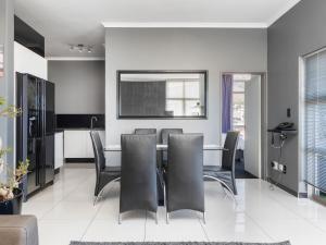 a dining room with a table and black chairs at Upper East Side 407 in Cape Town