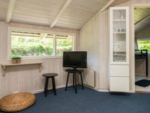 um quarto com uma televisão, um banco e uma janela em 5 person holiday home in B rkop em Egeskov