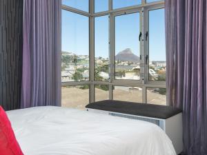 a bedroom with a bed and a large window at Upper East Side 407 in Cape Town