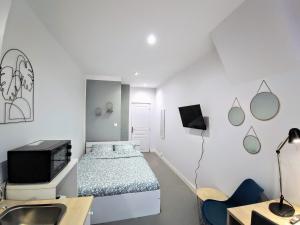 a white room with a bed and a sink at Palais du Luxembourg in Roubaix