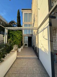 a walkway leading to a building with a door at VILLA ŠIMOVIĆ APARTMENTS in Baška Voda