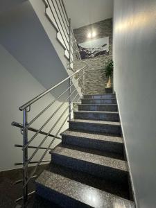 eine Treppe mit einer Steinwand und einer Treppe in der Unterkunft VILLA ŠIMOVIĆ APARTMENTS in Baška Voda