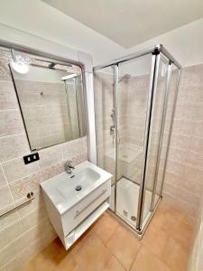 La salle de bains est pourvue d'un lavabo et d'une douche. dans l'établissement Vittoria holiday house - Tulip Apartment, à Stresa