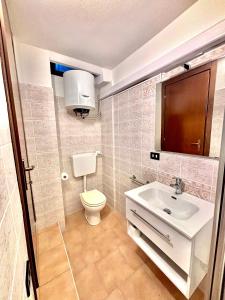 La petite salle de bains est pourvue de toilettes et d'un lavabo. dans l'établissement Vittoria holiday house - Tulip Apartment, à Stresa
