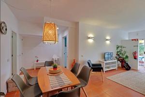 a living room with a dining room table and chairs at Falésia Sunny Apartment in Quarteira