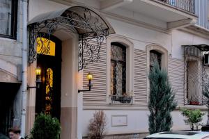 a white house with an ornate door and window at Luxor Gardens in Batumi