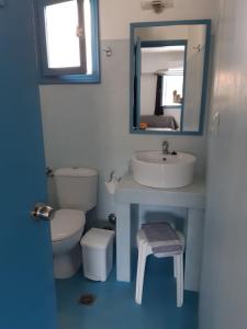 uma casa de banho com um lavatório, um WC e um espelho. em Delfini Hotel em Skala