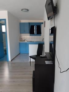 a living room with blue cabinets and a black couch at Delfini Hotel in Skala