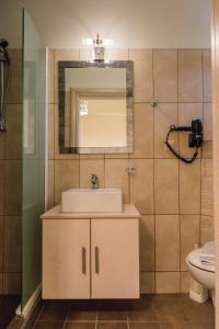 bagno con lavandino e specchio di Hotel Sunshine Matala a Mátala
