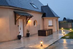 eine Terrasse mit Lichtern vor einem Haus in der Unterkunft Villa Katharos avec SPA et piscine in Vesly