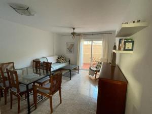 een woonkamer met een tafel en stoelen en een bank bij adosado con piscina en Cabo de Gata 4p in El Cabo de Gata