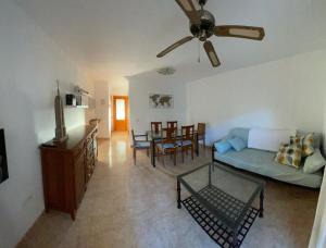 een woonkamer met een bank en een tafel bij adosado con piscina en Cabo de Gata 4p in El Cabo de Gata