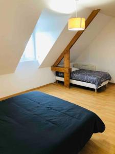 una camera da letto con letto in mansarda di Villa Katharos avec SPA et piscine a Vesly