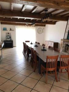 una sala da pranzo con un grande tavolo e sedie di Villa Katharos avec SPA et piscine a Vesly