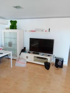ein Wohnzimmer mit einem Flachbild-TV auf einem weißen Schrank in der Unterkunft Casa de Verano con Piscina in Montroy