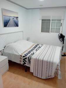 um quarto branco com uma cama e uma janela em Casa de Verano con Piscina em Montroy