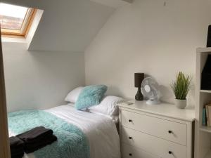 a bedroom with a bed and a dresser and a window at Henley Town Rooms in Henley on Thames