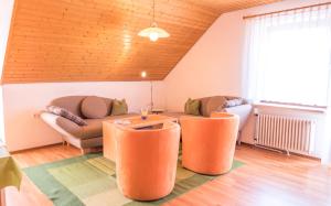sala de estar con sillas de color naranja y sofá en Haus Schwörer, en Hagnau