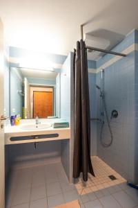 a blue bathroom with a sink and a shower at MAGNET Boardinghouse in Schkeuditz