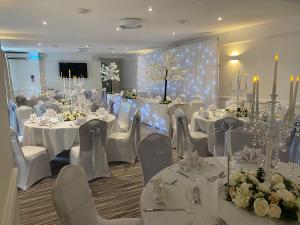 a banquet room with white tables and white chairs at Lion Hotel in Worksop