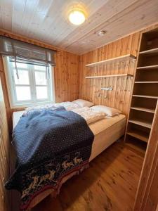 1 dormitorio con 1 cama en una habitación de madera en Sjarmerende leilighet i Sirdal, en Haugen