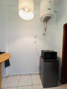 a room with a white wall and a microwave on a table at Los Angeles to Conakry *KIPE* in Conakry