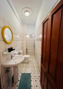 ein Badezimmer mit einem Waschbecken, einem WC und einem Spiegel in der Unterkunft Los Angeles to Conakry *KIPE* in Conakry