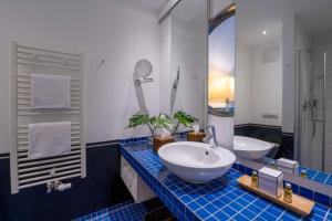 a bathroom with two sinks and a large mirror at Precise Resort Hafendorf Rheinsberg in Rheinsberg