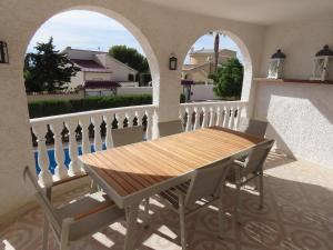 uma mesa de madeira e cadeiras numa varanda em Villa Descansa em Ciudad Quesada
