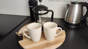 duas canecas de café sentadas numa tábua de cortar madeira em Võhma industriaal pesa 