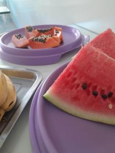 two purple plates with slices of watermelon on them at Hotel e Pousada Mape Ltda in Guanamby