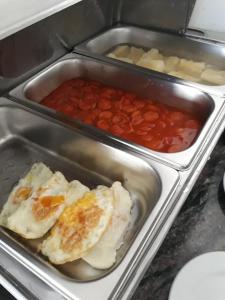 una estufa con tres bandejas de comida. en Hotel e Pousada Mape Ltda, en Guanambi