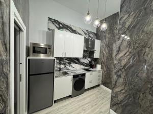 a kitchen with white appliances and a marble wall at Madrid tofi 3 in Madrid