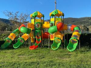 a bunch of playground equipment in the grass at Chalet Camping River Italië met 2 slaapkamers in Ameglia