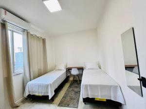 biały pokój z 2 łóżkami i oknem w obiekcie Apartamento alto padrão na Doca w mieście Belém