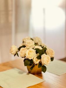 un vaso pieno di rose bianche, seduto su un tavolo di Dubaï to Conakry KIPE a Conakry