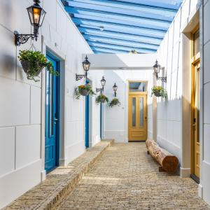 a walkway with blue doors and a bench at Grapèlli Boutique Hotel in Alkmaar