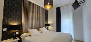 a bedroom with a white bed and a black wall at Hostal Luna de Nerja HMA 02340 in Nerja