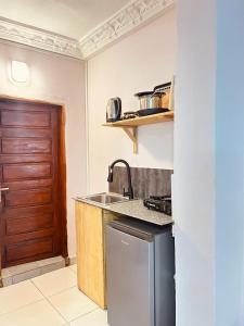 eine Küche mit einem Waschbecken und einer Holztür in der Unterkunft Dubaï to Conakry KIPE in Conakry