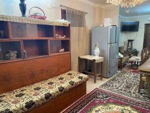 ein Wohnzimmer mit einem Bett und einem Kühlschrank in der Unterkunft Elnoras city ismailia in Ismailia
